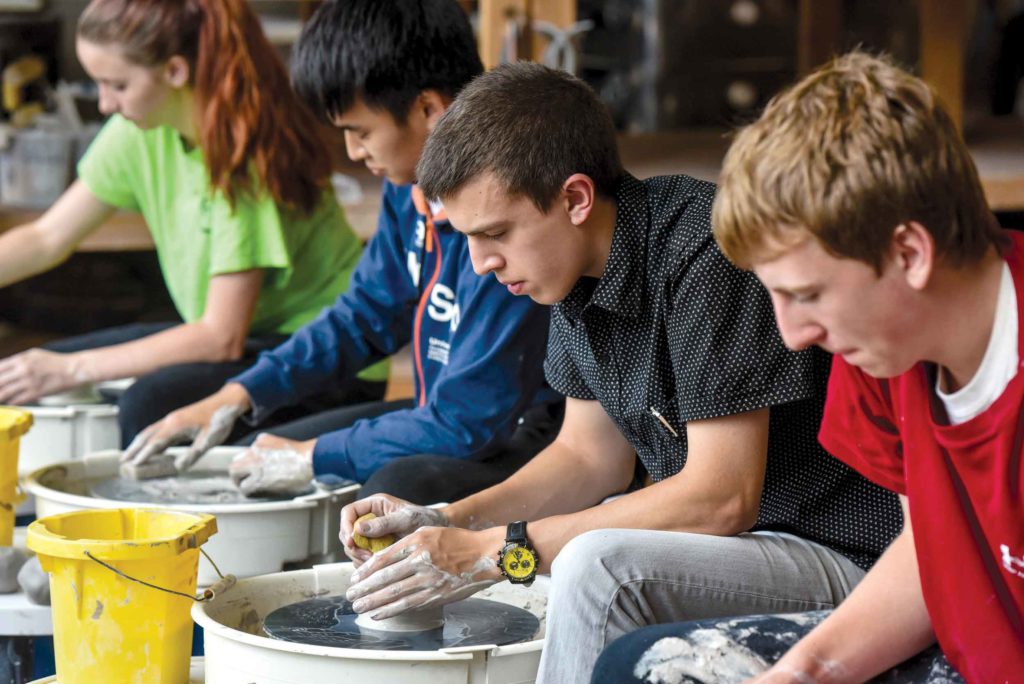 Students working at pottery wheel