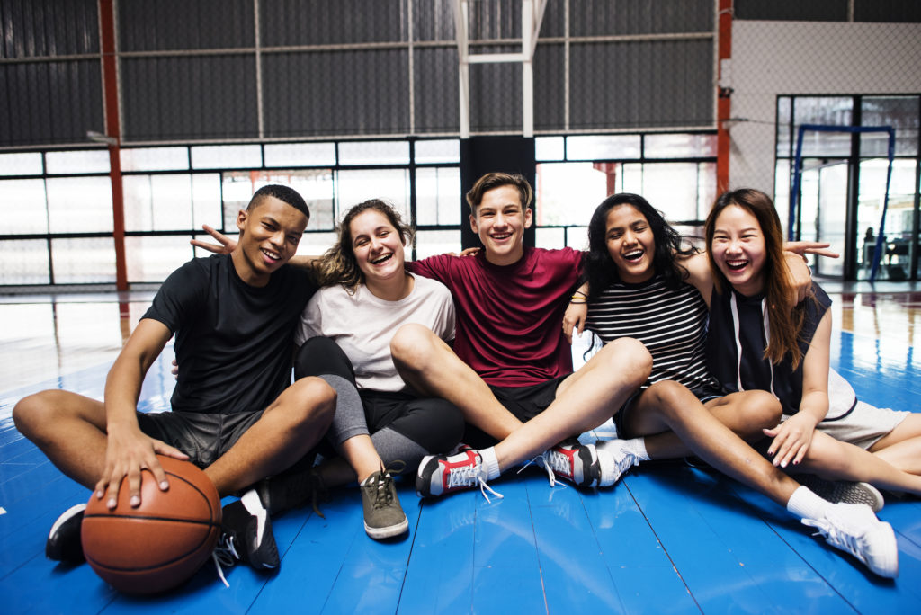 Group of teens sitting together in a gym