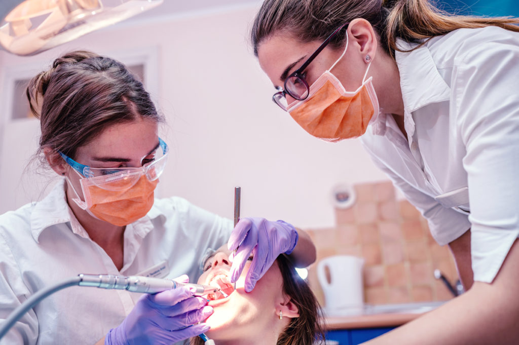 Dentist and dental assistant working on patient