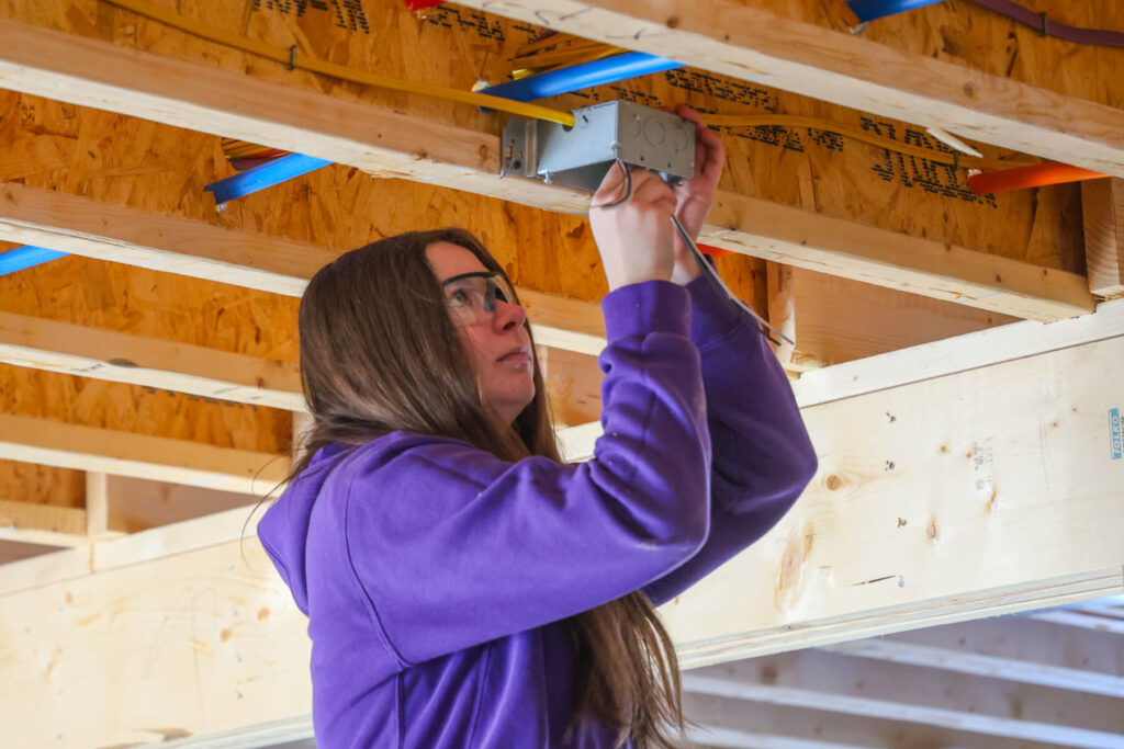 student installing electrical outlet.