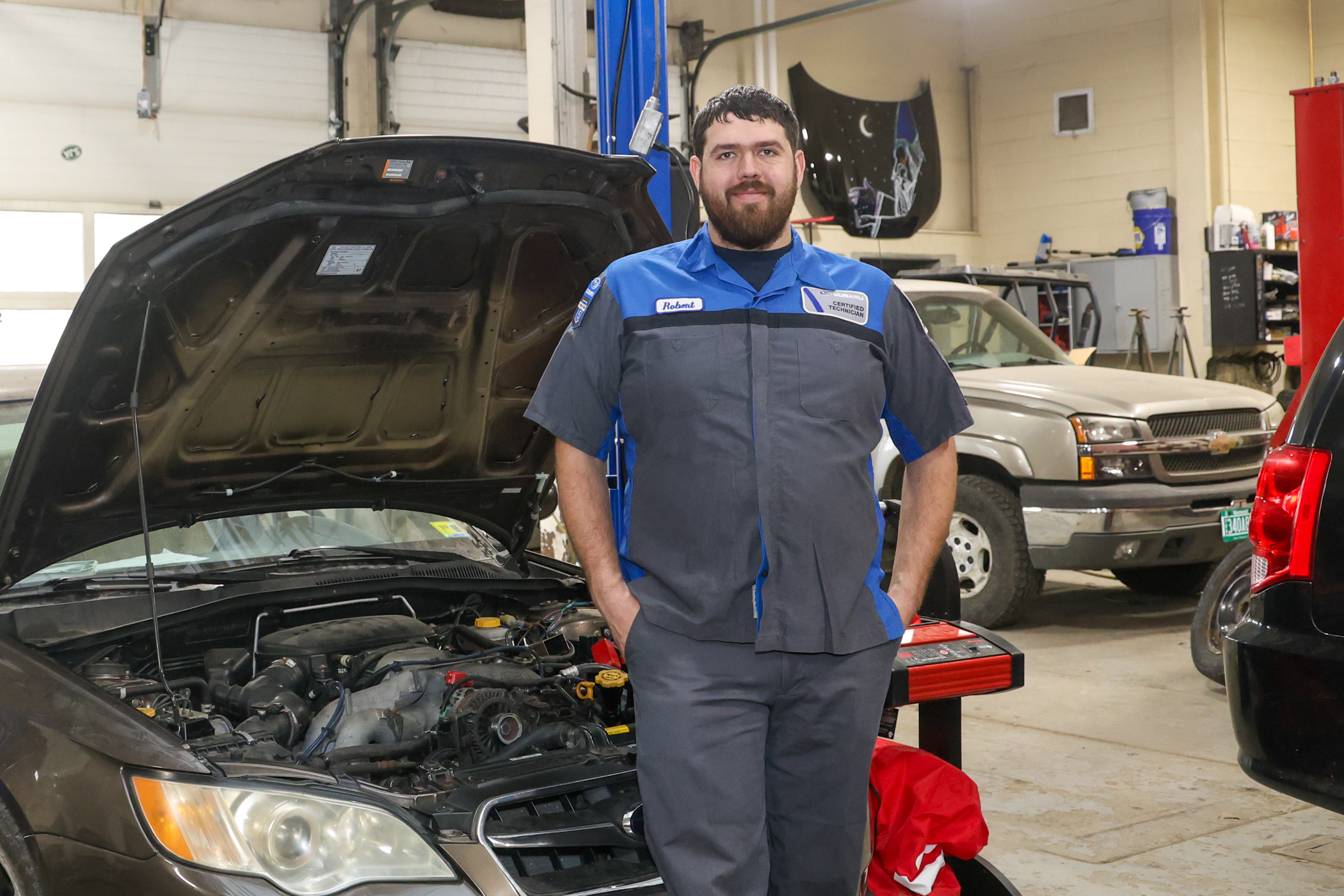 an auto mechanic stands in front of a car