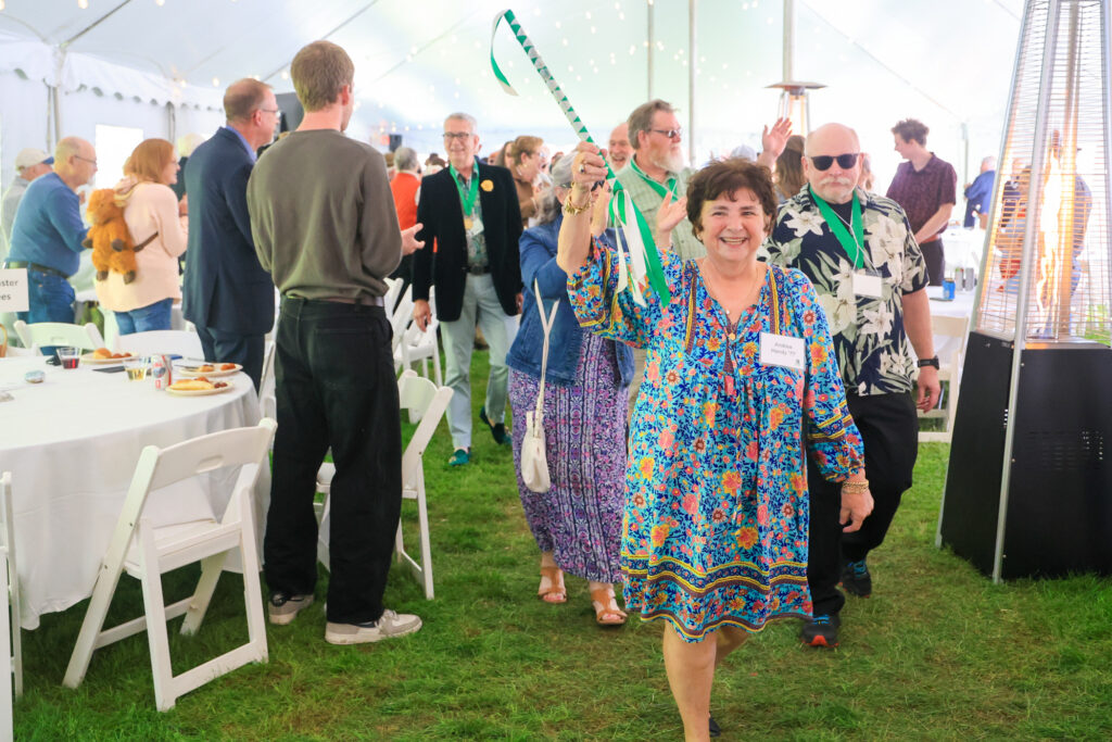 The Class of 1976 enters the tent for alumni weekend