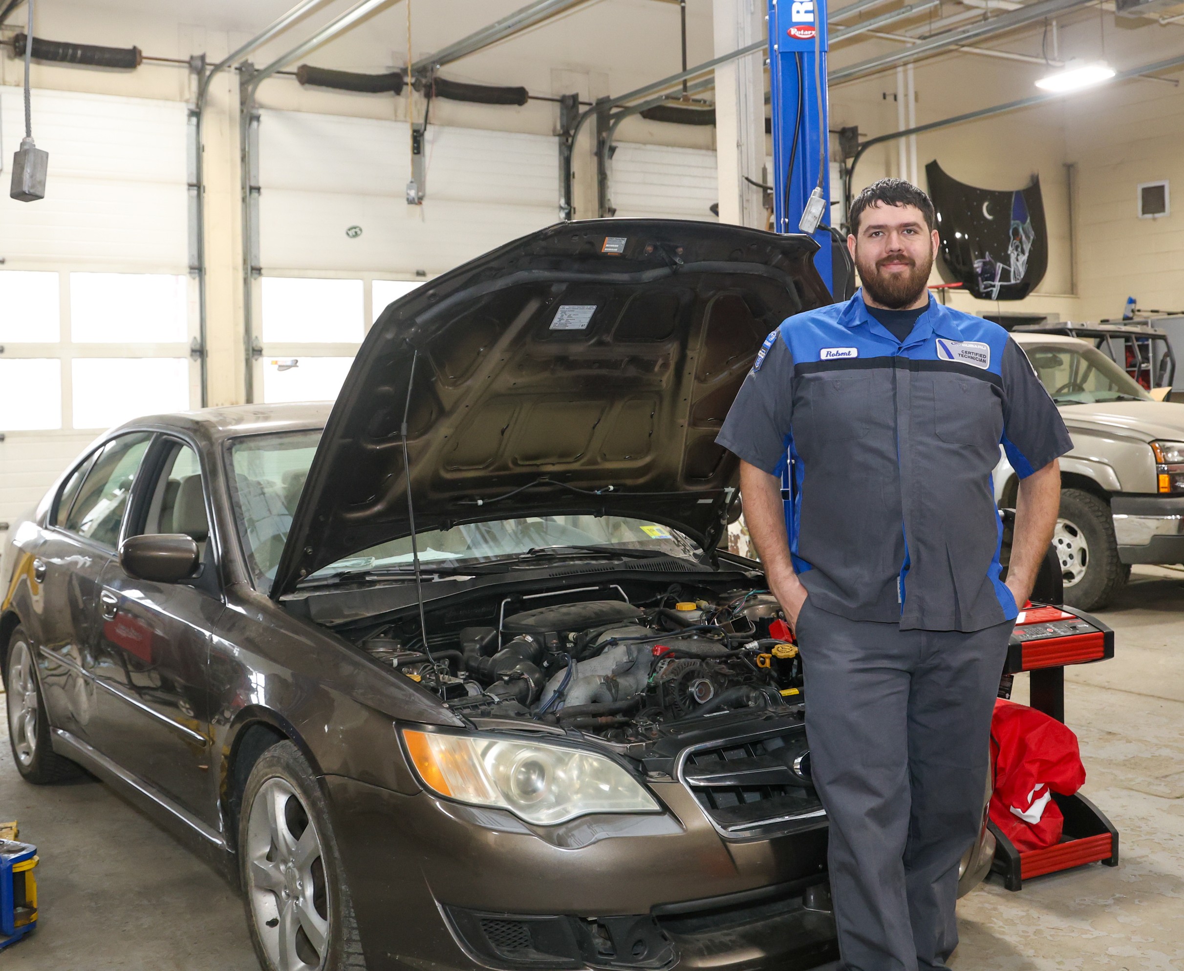 Man stands next to car with hood open