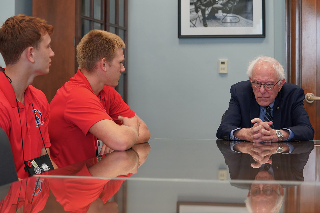 Students sit with US Senator Bernie Sanders.
